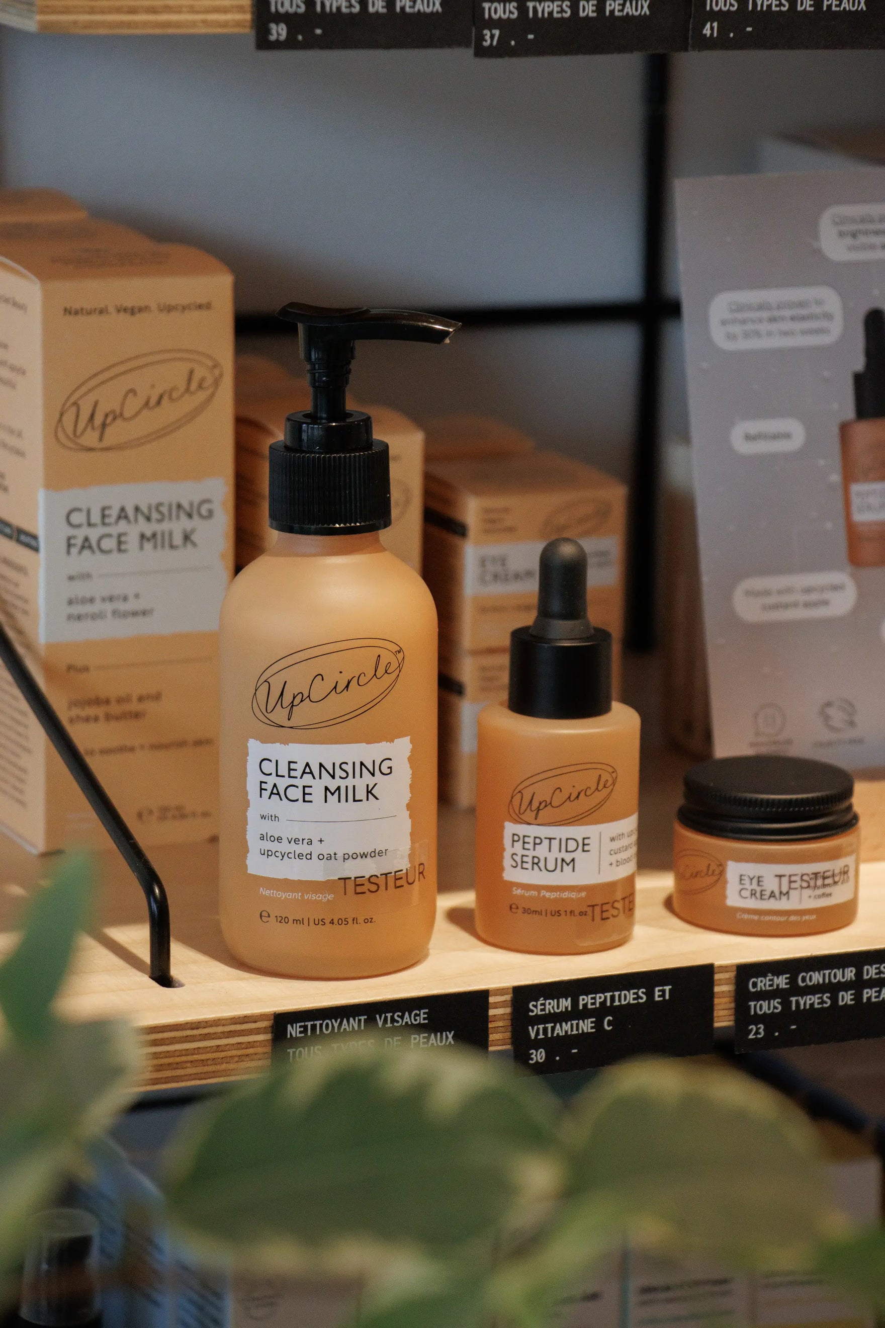 Upcircle skincare on a shop shelf surrounded by greenery 