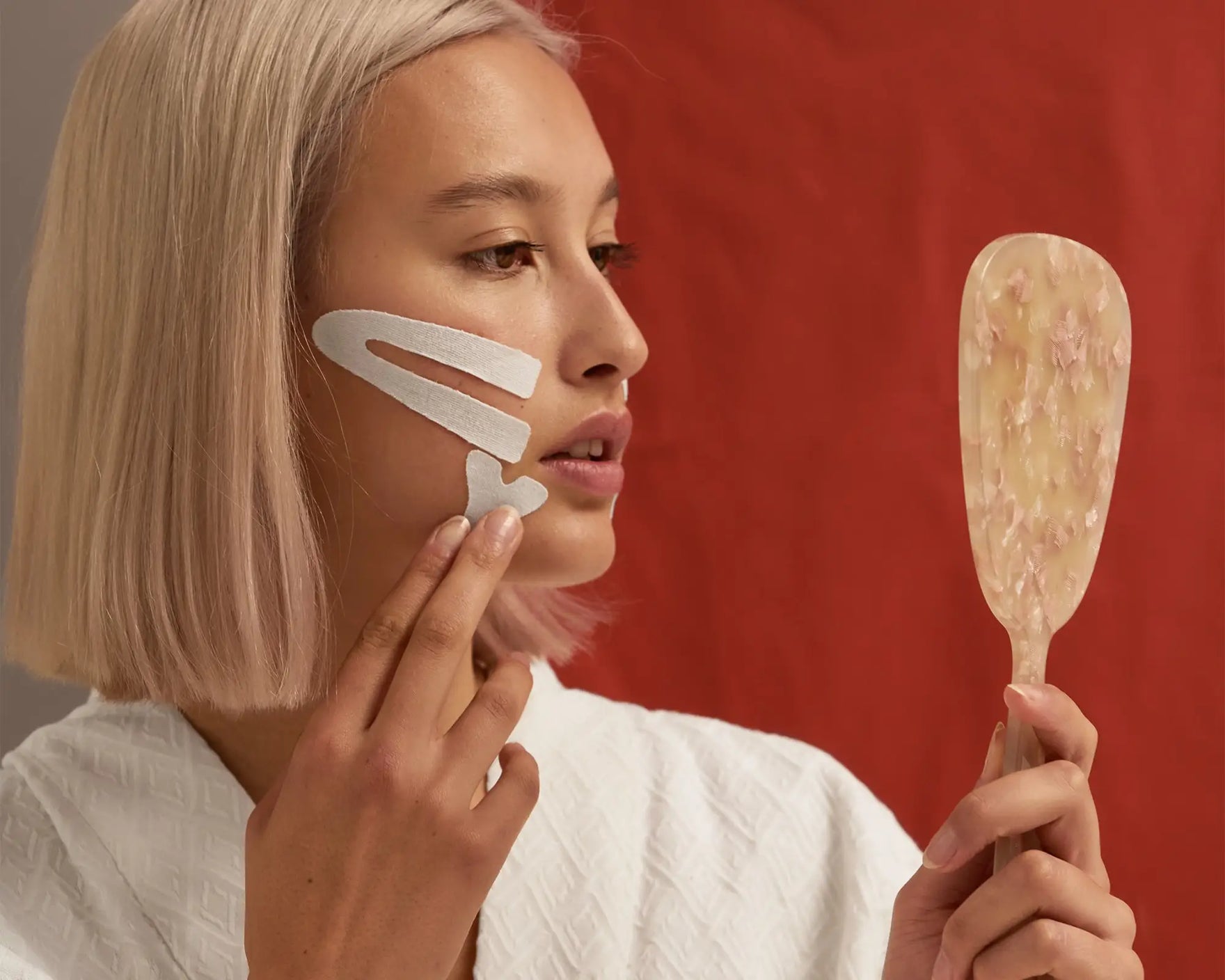 Woman wearing kensiotape on her cheekbone and jaw line