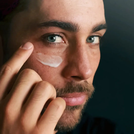 A close-up of a male face applying Jungkraut Alpine Performance Face Fluid to his cheek.