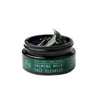 bepure Calming Milk face cleanser in an open dark green glass jar, with a dollop of deep green balm on top.