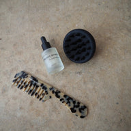 Conscious Botanist hair care set comb serum and scalp massager on beige background