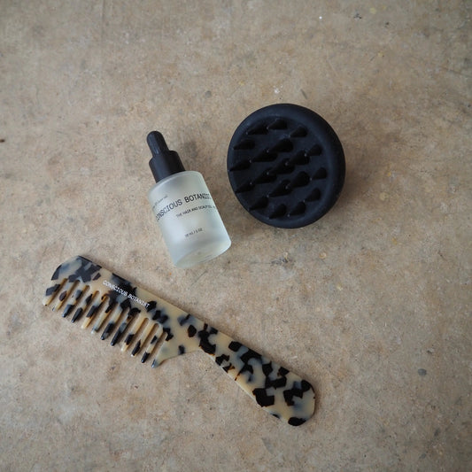 Conscious Botanist hair care set comb serum and scalp massager on beige background