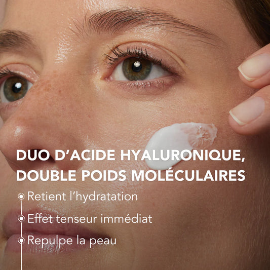 Close-up of a woman’s face with “On the Wild Side” Light Day Fluid applied to her skin, alongside on-photo text highlighting a hyaluronic acid duo.