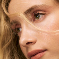 Close-up of person with blonde hair and green eyes wearing Eclo brown eyeliner pencil