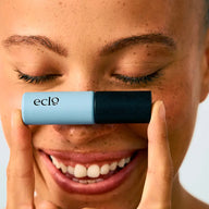 Person holding Eclo Black mascara in front of their face