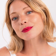 Woman with blonde hair smiling wearing Eclo 3-in-1 lip pencil Fuchsia Vibrant 003