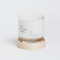 Hetkinen Biofilia Candle in a glass jar with a wooden coaster on a white background