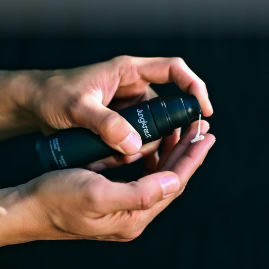 Close-up of a man's hands pressing the Mountain Intense Face Cream pump, with the cream emerging from the nozzle.