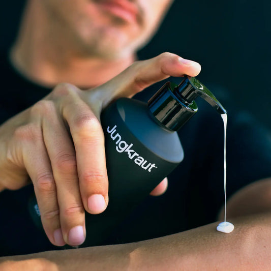 Person applying Jungkraut Wild Forest Body Lotion to their arm with a close-up view.