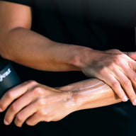 Person applying Jungkraut Wild Forest Lotion to their arm with a black background