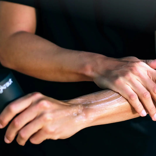 Person applying Jungkraut Wild Forest Lotion to their arm with a black background