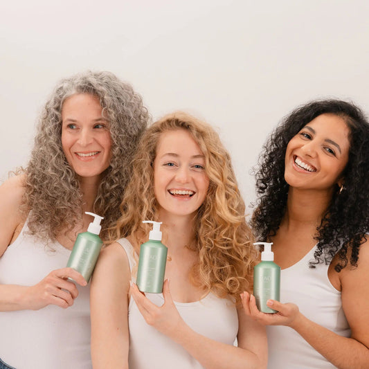 Three women with curly hair types holding LAO CARE Light Curl Jelly green bottles against a white background