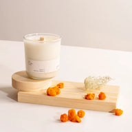 Hetkinen Lapland Candle on a wooden coaster with dried flowers on a light background