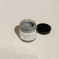 Jar of purifying mask 2-in-1 by On the Wild Side with a black lid on a light beige background
