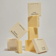 Collection of beige soap boxes and unboxed soaps from Refeel Naturals on a light gray background