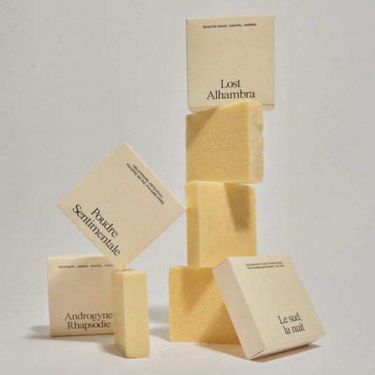 Collection of beige soap boxes and unboxed soaps from Refeel Naturals on a light gray background