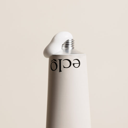 Eclo Regenerating Hand Balm metal tube with visible white cream coming out