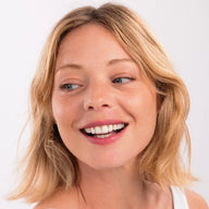 Woman with blonde hair smiling wearing Eclo 3-in-1 lip pencil Rose Velvet 004