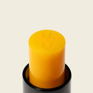 Close-up of Uoga Uoga Spritzberry yellow lip balm stick