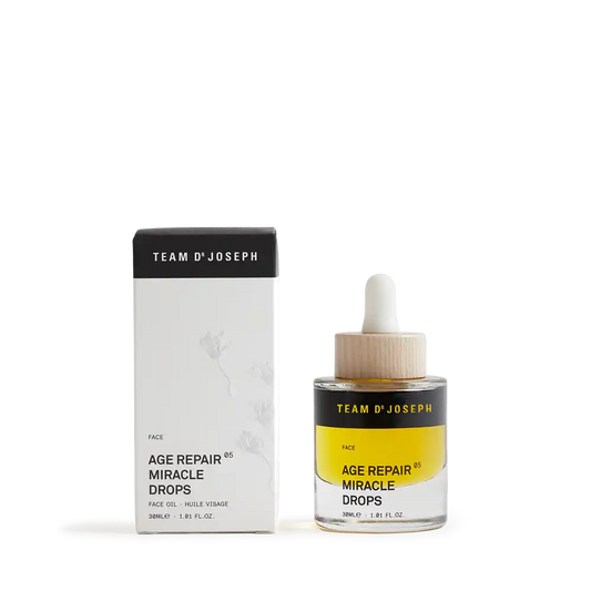 TEAM DR JOSEPH Age Repair Miracle Drops 30 ml face oil in a glass bottle with a wooden pipette cap, beside its black and white outer box