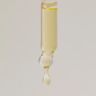 Glass pipette releasing a golden drop of TEAM DR JOSEPH Age Repair Miracle Drops face oil