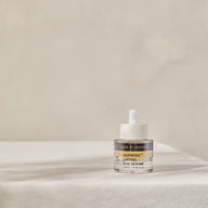 TEAM DR JOSEPH Supreme Lifting Eye Serum 15 ml standing on a linen-covered table in soft natural light