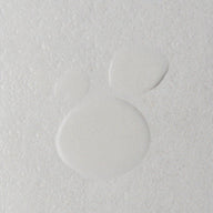Macro view of Twelve Beauty Dara's Water, highlighting its white textured surface and two circular depressions.