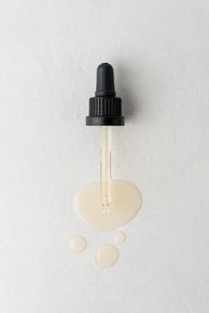 Close-up of a pipette dispensing Twelve Beauty Ideal Rebalancing Level Serum, with the liquid’s smooth, slightly viscous texture clearly visible.