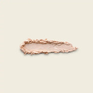 Uoga Uoga Game of Lights highlighter — a pressed powder in a light peach-beige shade with a soft satin finish.