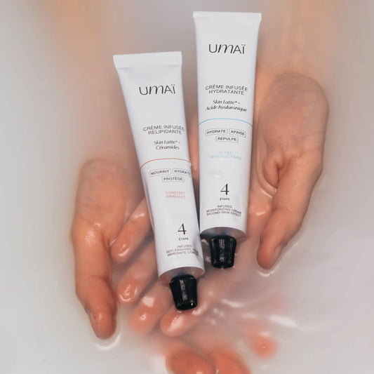 Two Umai face creams held by a person with a blurred background