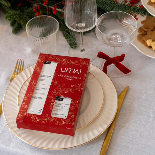Umai Les Essentiels Gift Set displayed on a Christmas-themed table setting with wine glasses, a red card, and festive decorations.