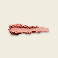 Uoga Uoga 643 Peachy blush textured swipe of pressed powder blush in a dusty rose pink shade, displayed horizontally on a solid light beige background.