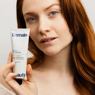 Femme tenant le gel nettoyant Go For Glow de Demain Beauty près de son visage