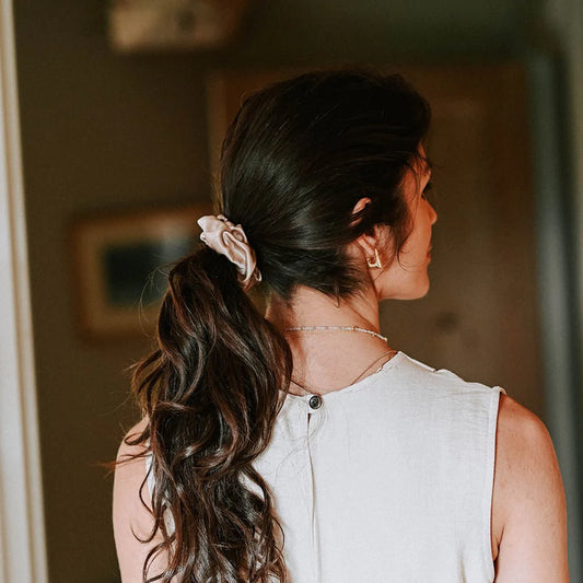 Woman wearing Hydra Studio beige scrunchie styled ponytail soft indoor setting